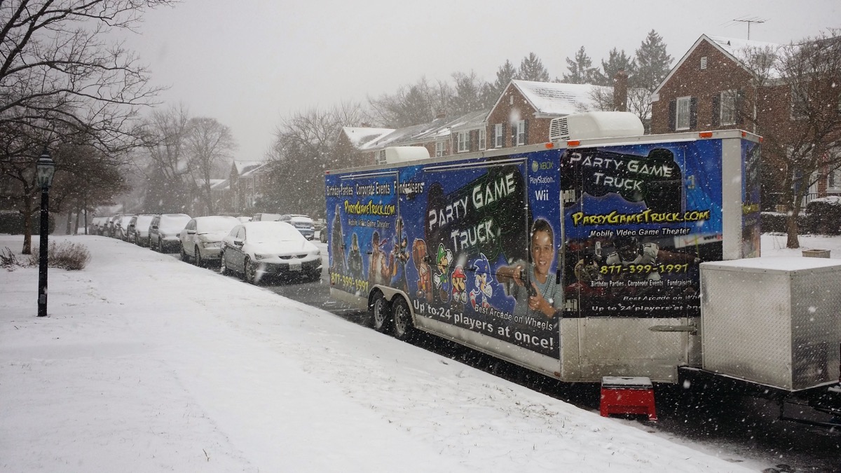 Two Party Game Trucks parked on a snowy street